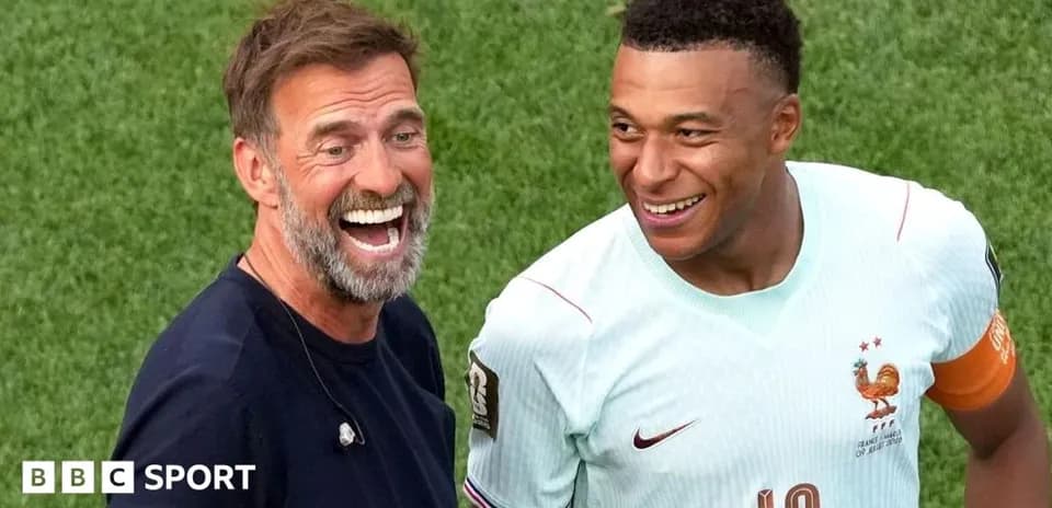 Coach and player smiling on the pitch after match