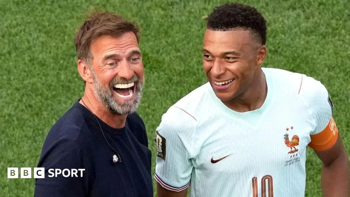 Coach and player smiling on the pitch after match