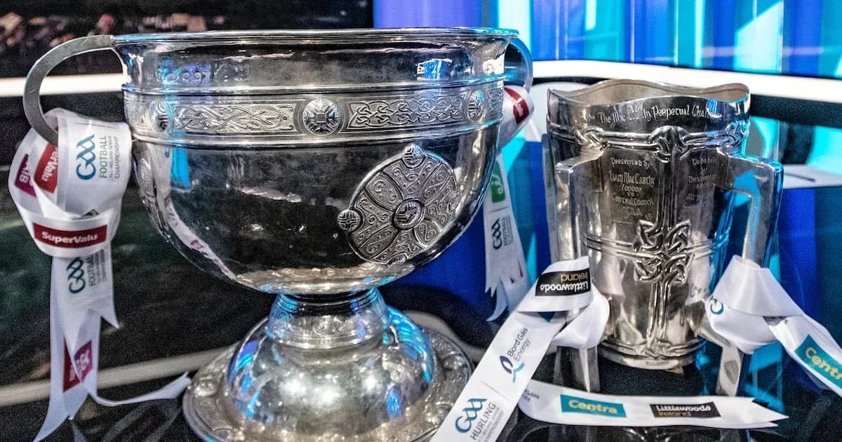 Two silver trophies with ribbons displayed on table