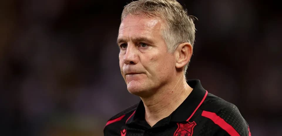 Coach wearing black shirt with red details
