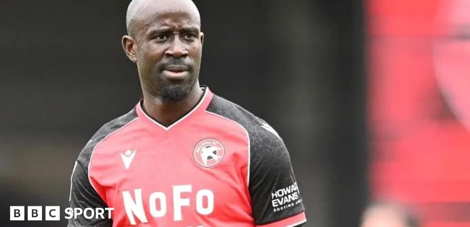 Player in red and black kit during match preparation