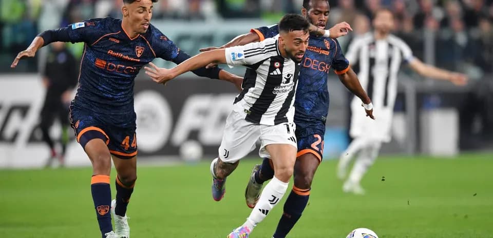 Juventus player evading Lecce defenders during match