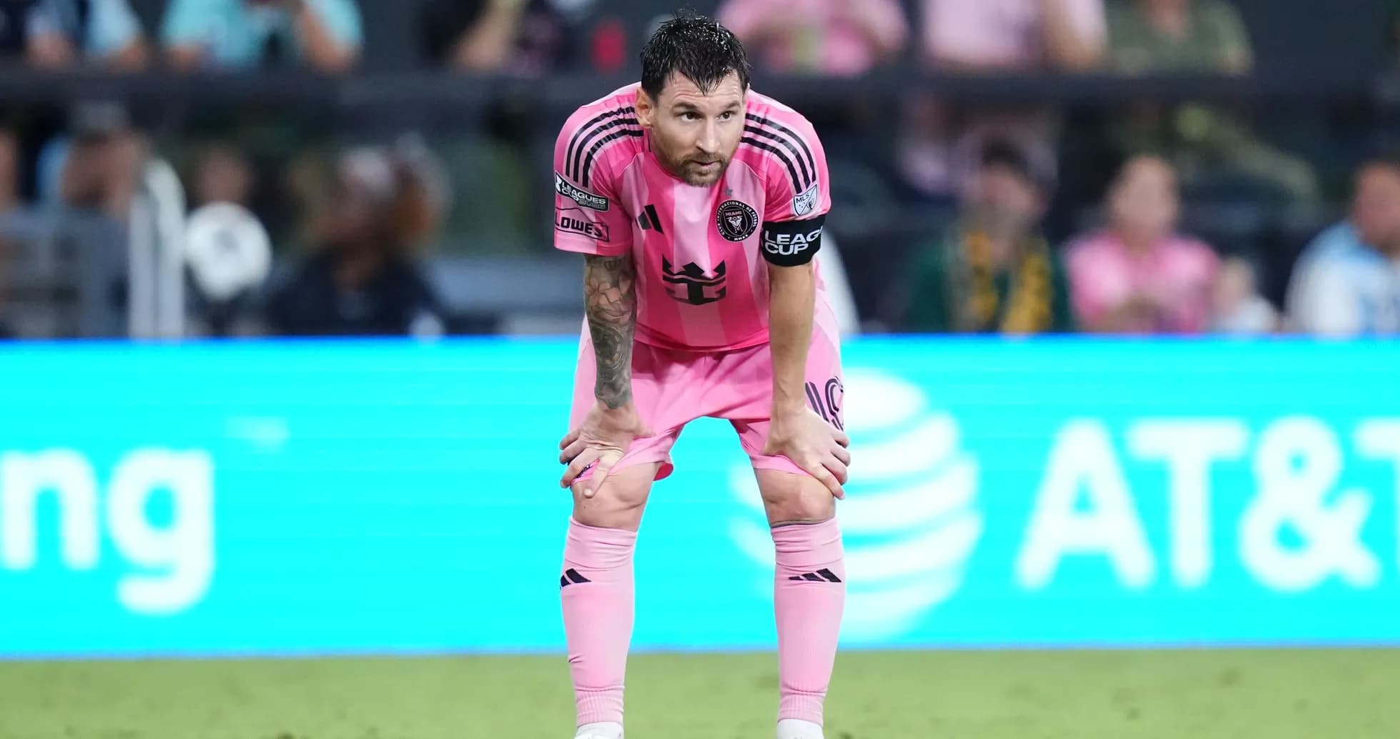 Player in pink uniform resting on the field
