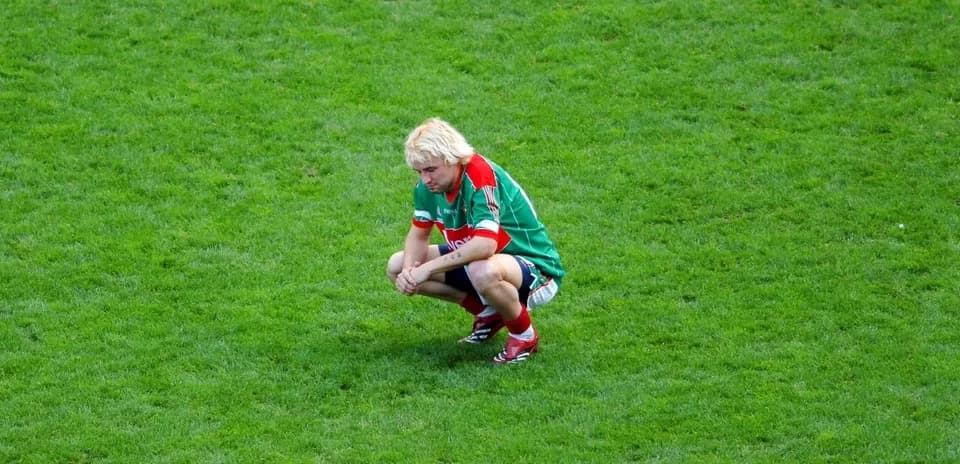 Player squatting on the pitch during match