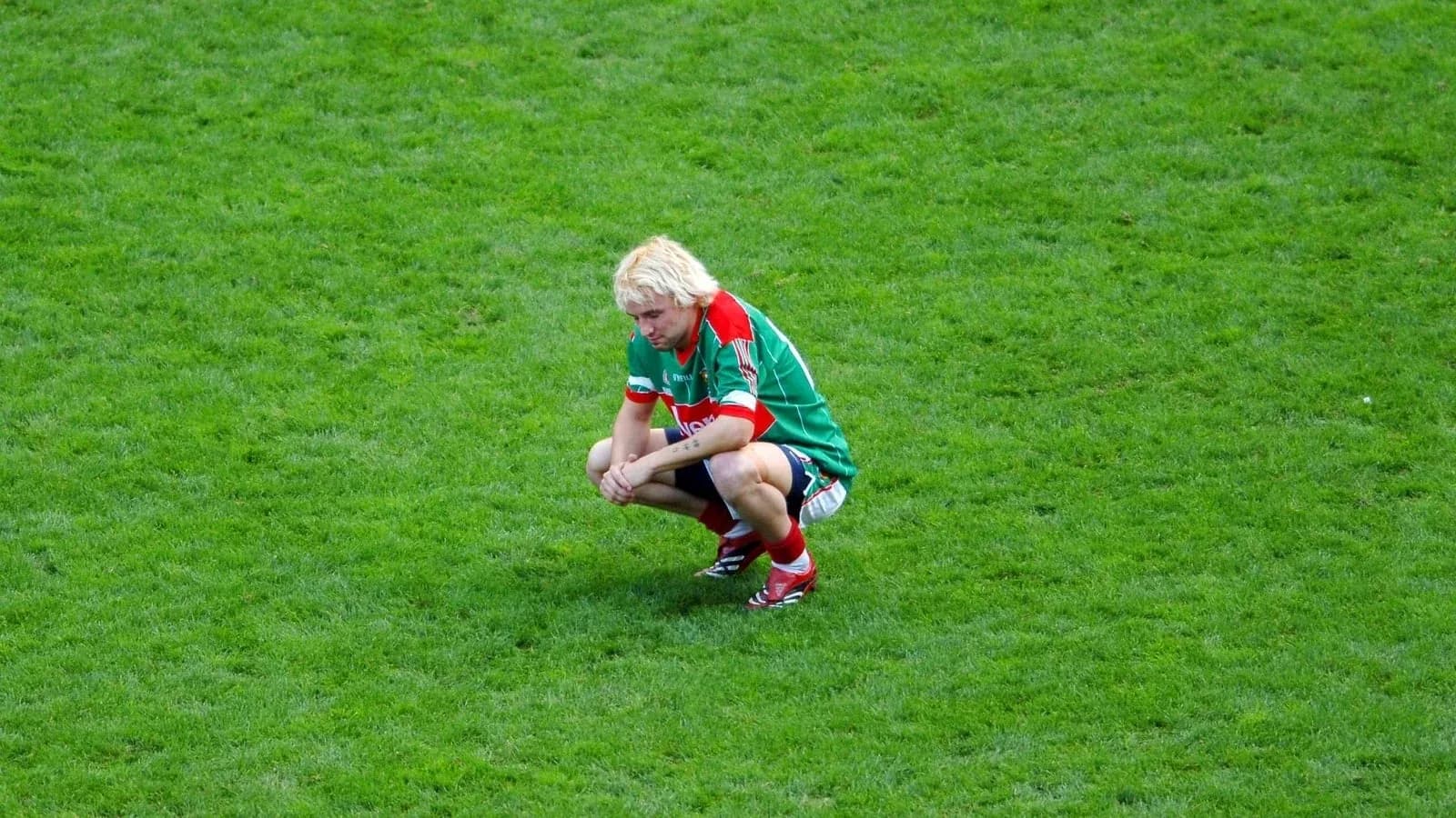 Player squatting on the pitch during match
