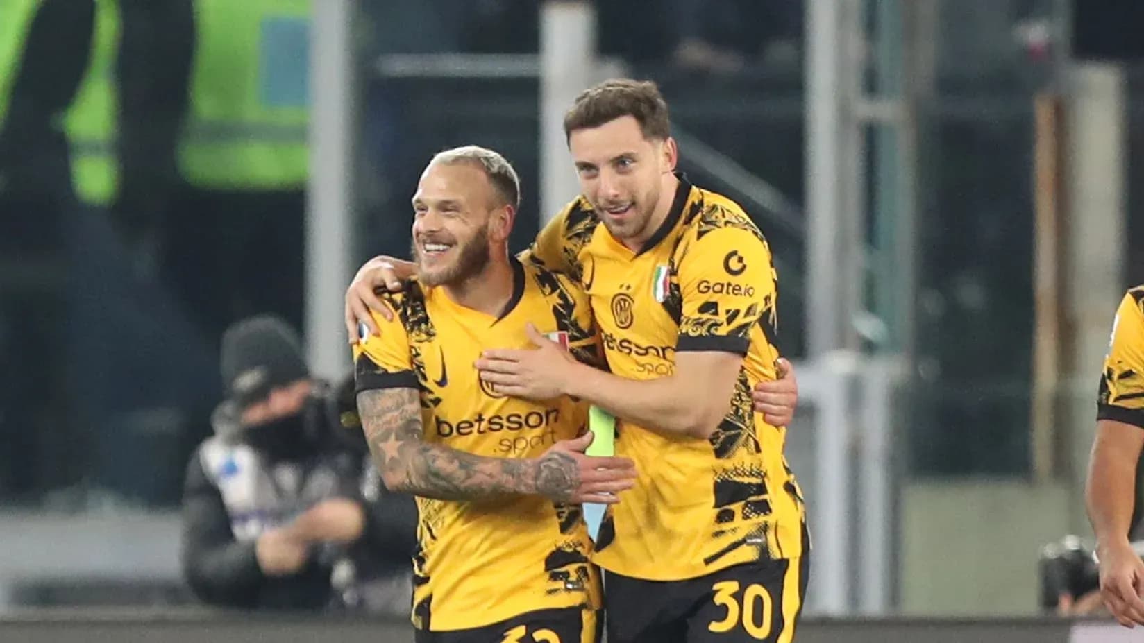 Two players celebrating a goal in yellow jerseys