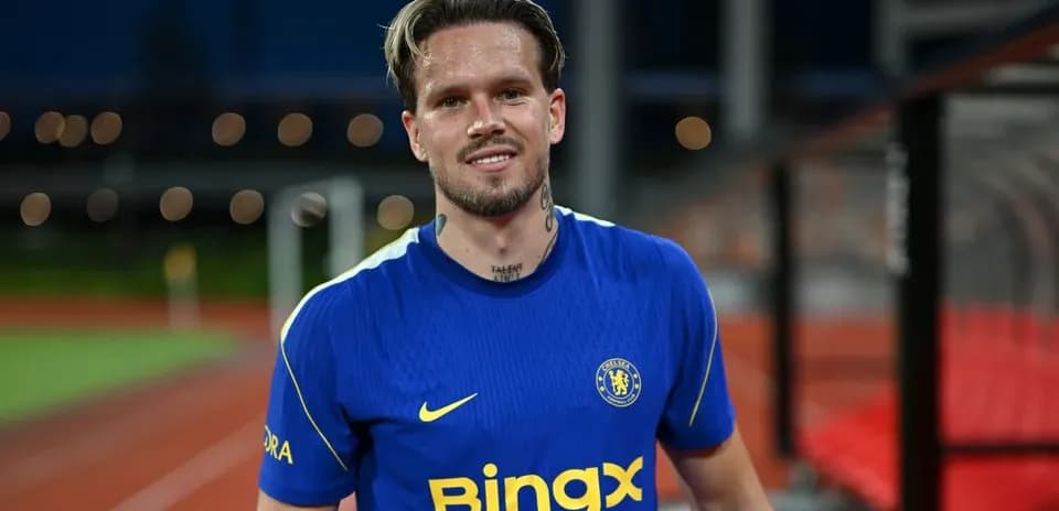 Player in Chelsea jersey smiling on the pitch