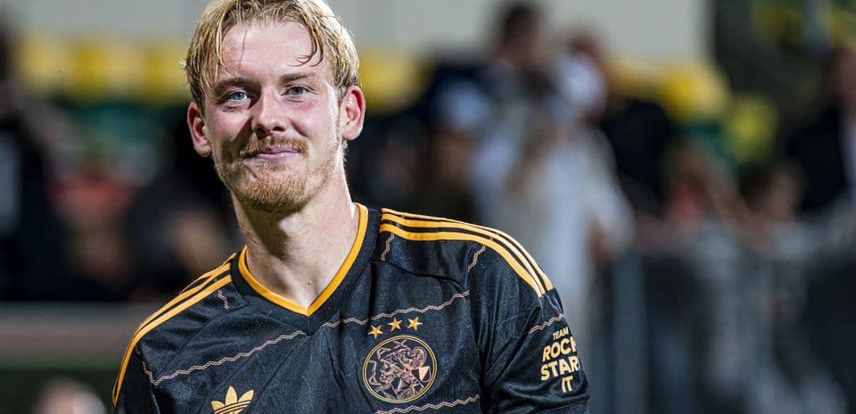 Football player in Ajax jersey smiling after match