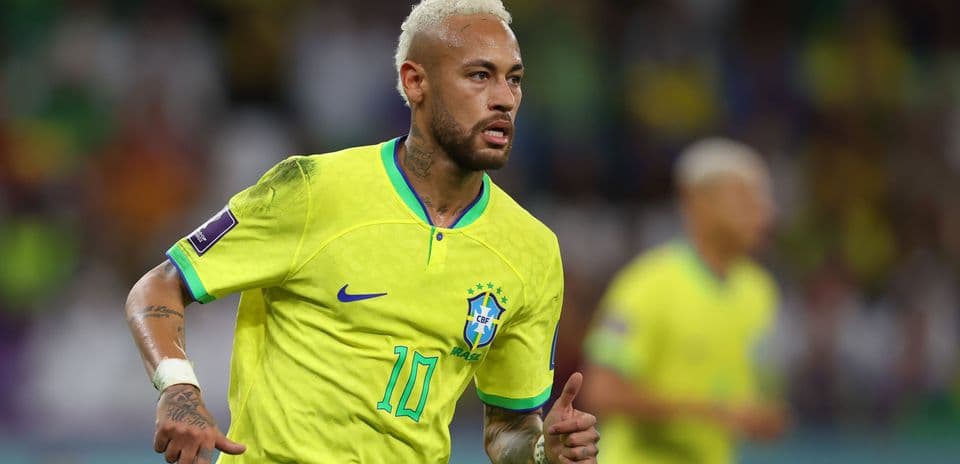 Neymar running in Brazil's yellow football kit