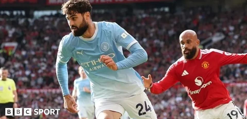 Manchester City player running with ball against Manchester United
