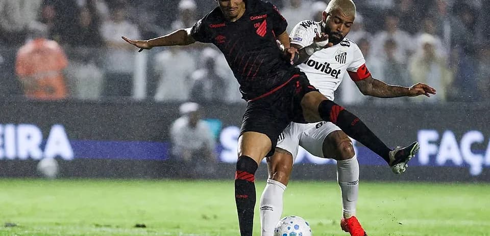 Players competing for the ball in rainy match