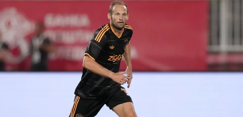 Player running during a football match in black kit