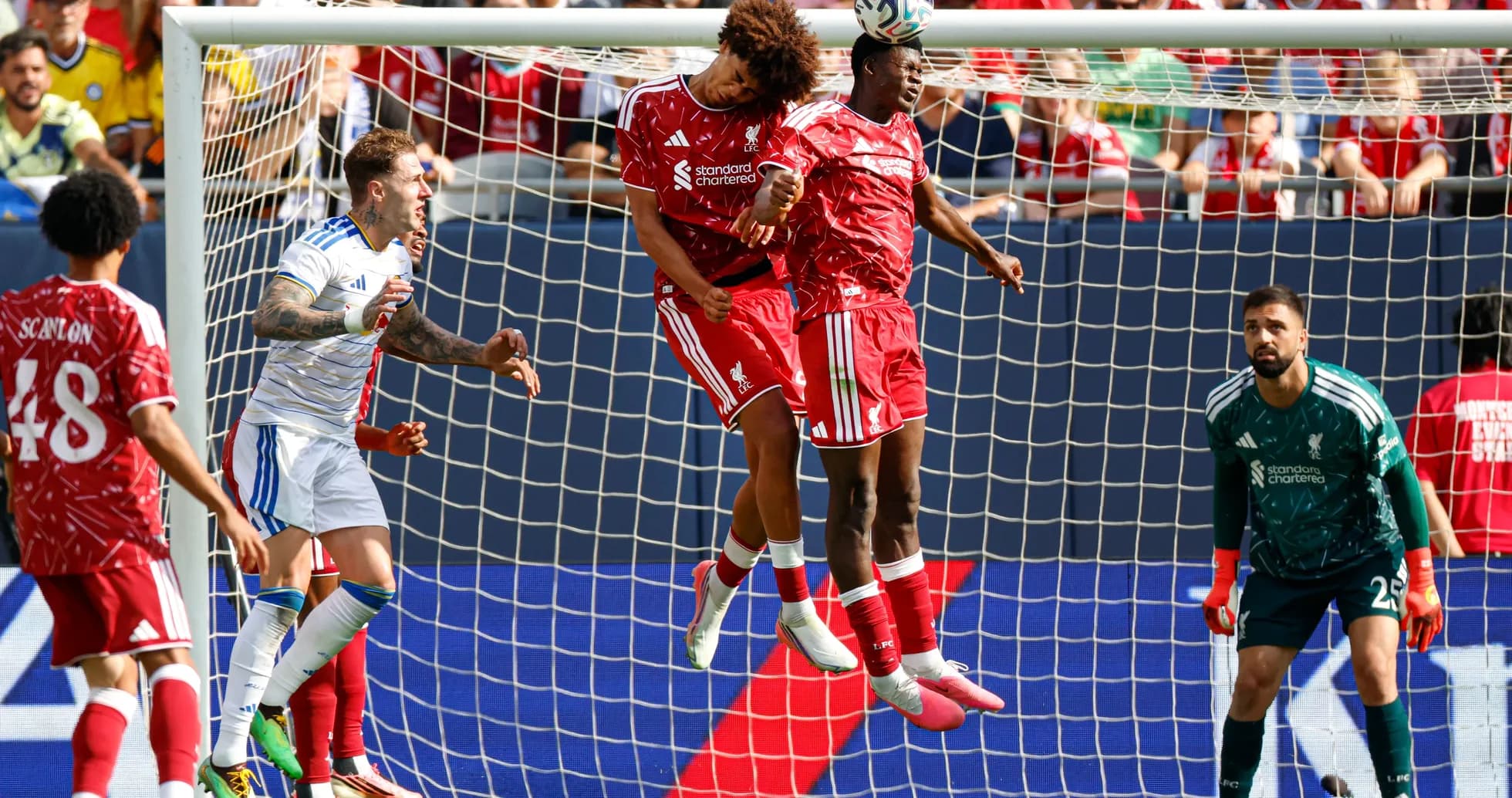 Two players heading the ball in a goal area