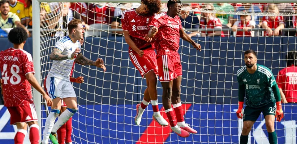 Two players heading the ball in a goal area