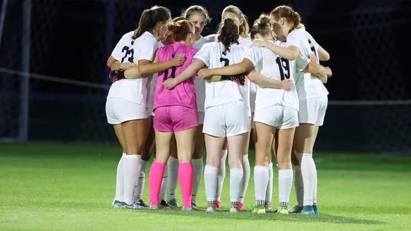 Soccer team huddling together before match