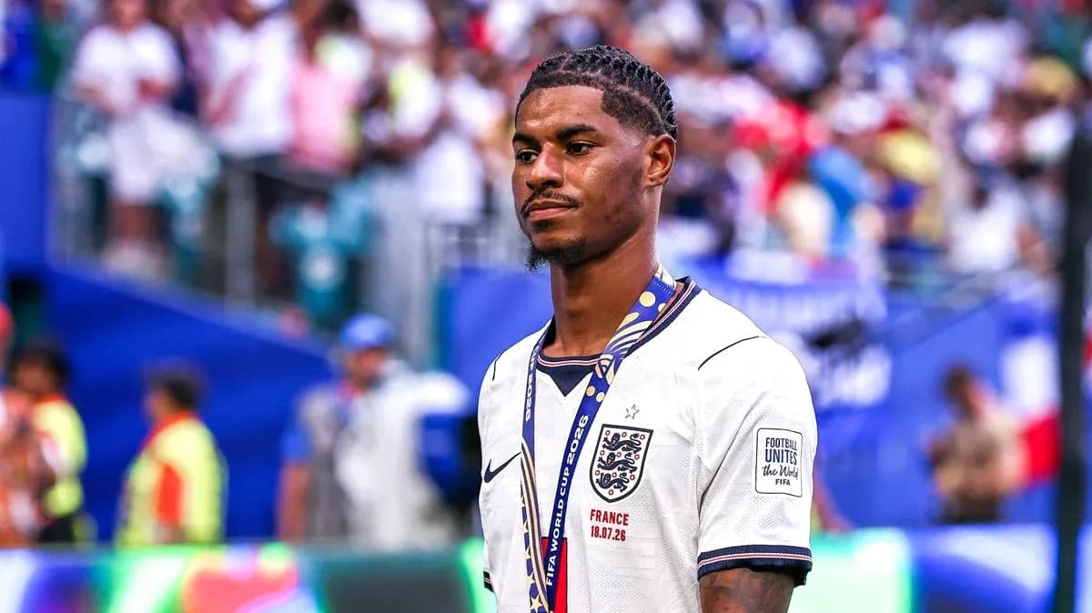 Player in England jersey with medal on pitch