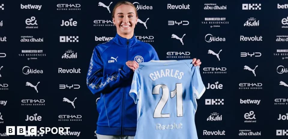 Player holding Manchester City jersey at announcement event