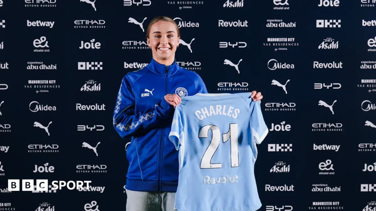 Player holding Manchester City jersey at announcement event
