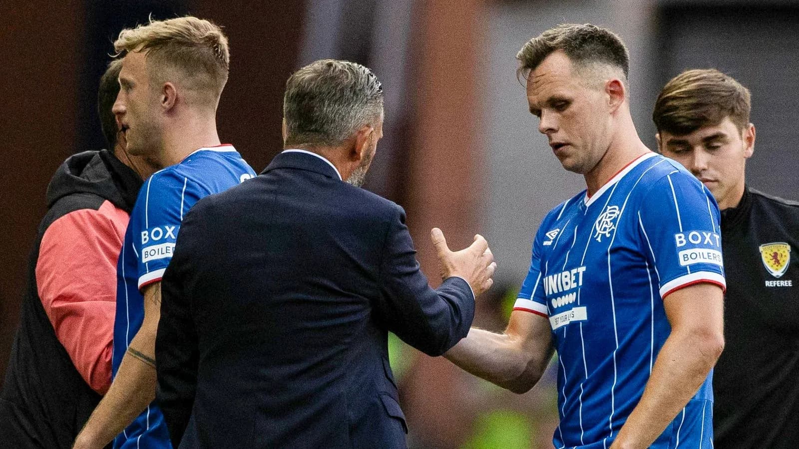 Rangers players interacting with coach during substitution
