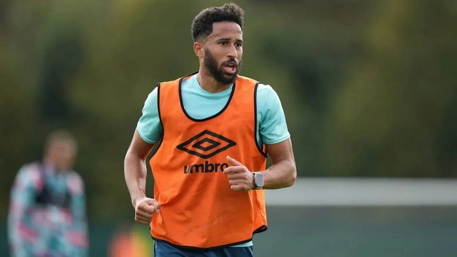 Player running during training session in orange vest