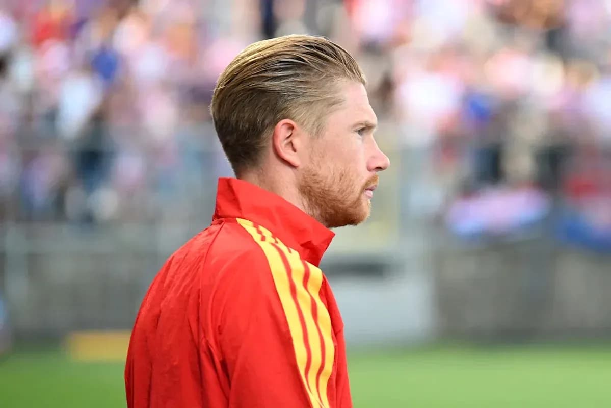 Player in red jacket observing the match
