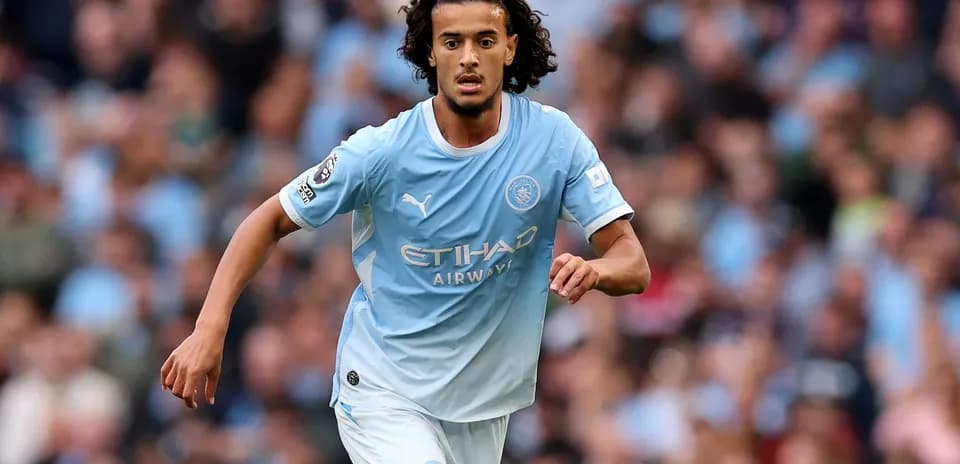 Player running on pitch in Manchester City kit