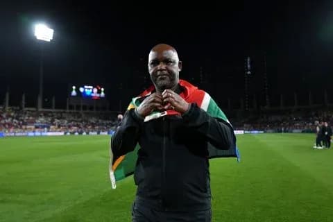Coach celebrating with South African flag on field