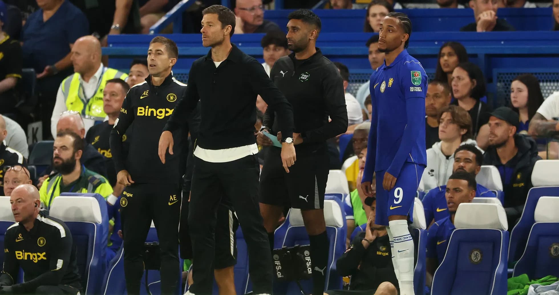 Coaches and player on sidelines during match