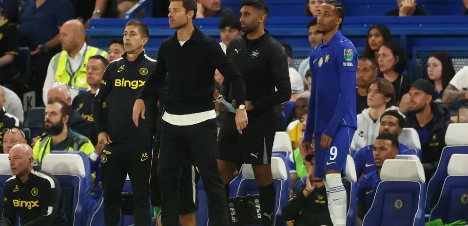 Coaches and player on sidelines during match