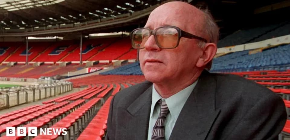 Man in glasses seated in empty stadium stands
