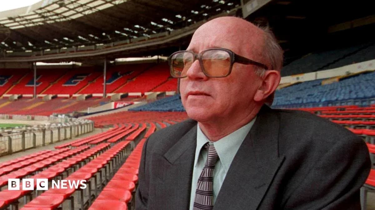 Man in glasses seated in empty stadium stands