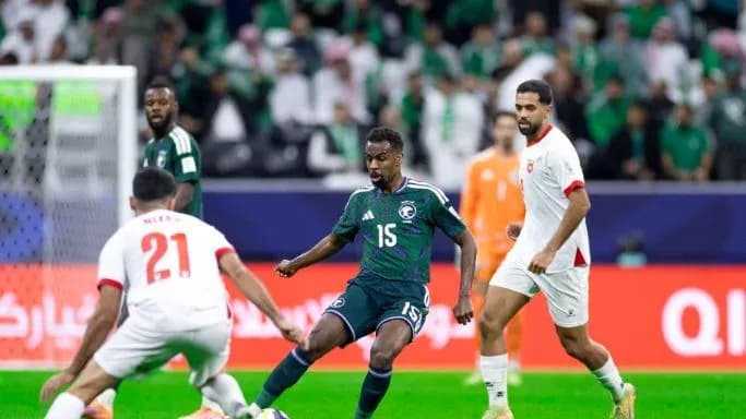 Saudi Arabia player dribbling past two opponents