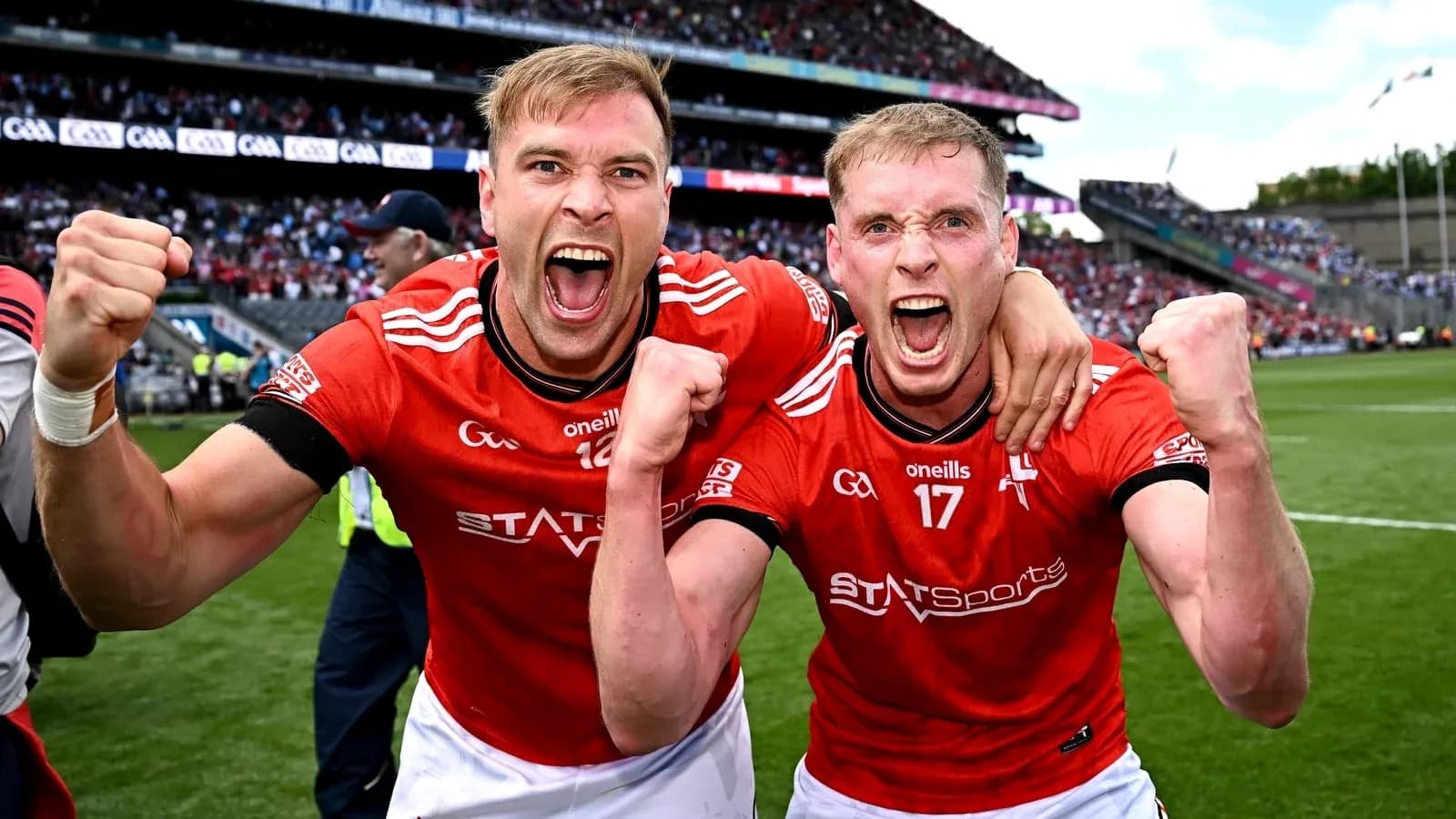 Two players celebrating in red jerseys on field