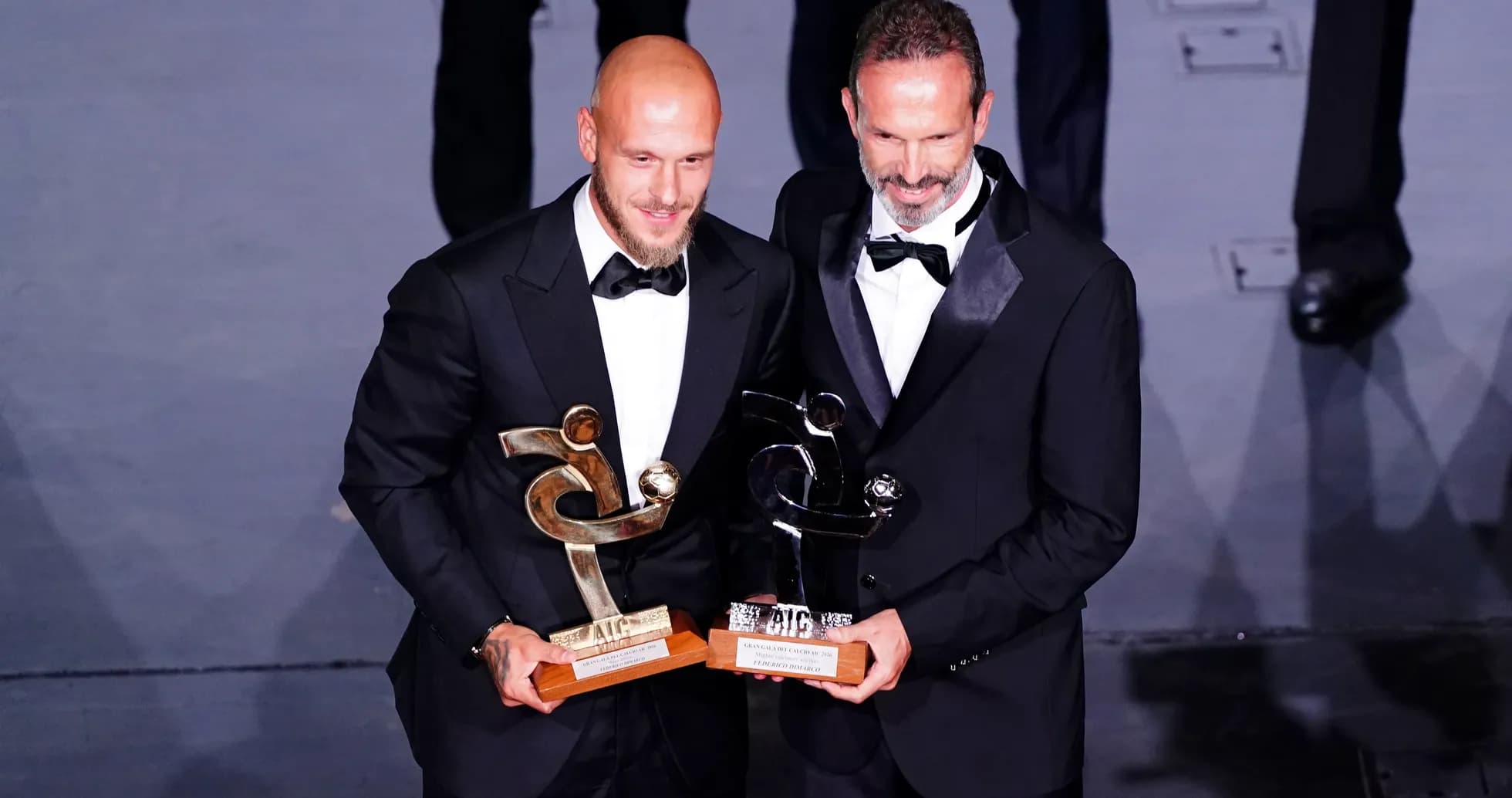 Two award winners posing with their trophies