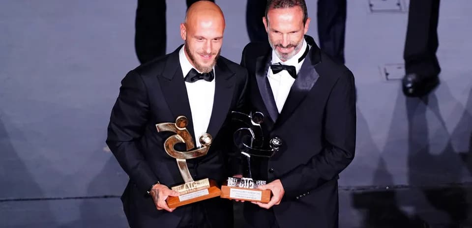 Two award winners posing with their trophies