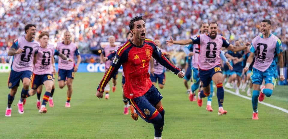 Spain player celebrating while teammates run behind