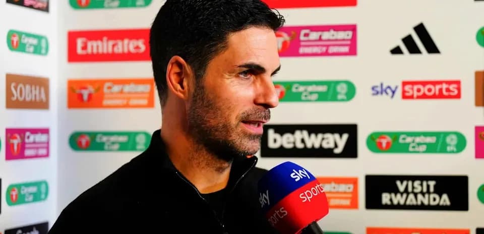 Manager speaking during post-match interview with microphone