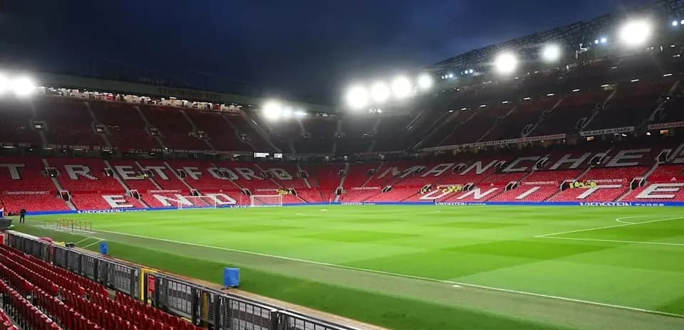 Empty Old Trafford stadium with bright floodlights