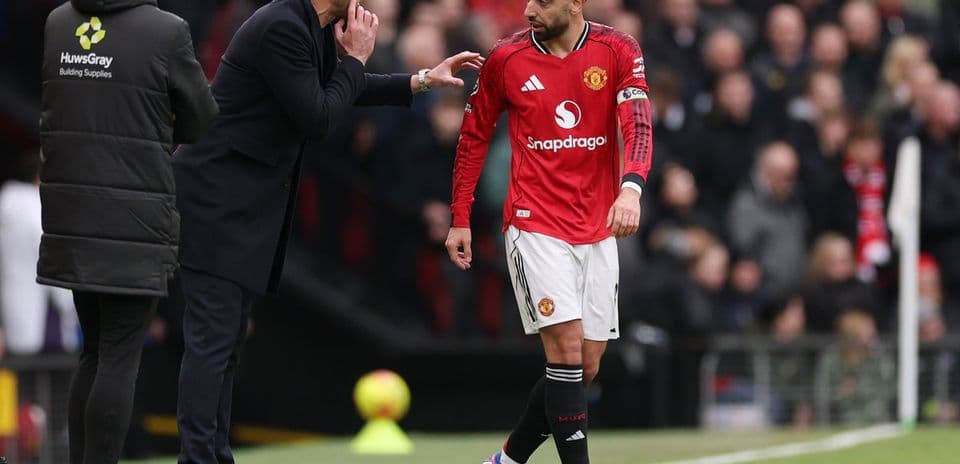 Manager discussing strategy with player during match