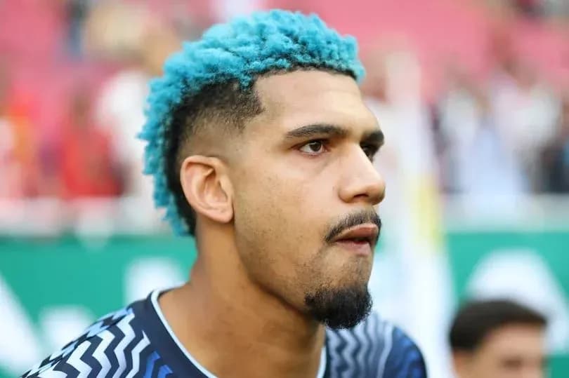 Player with blue hair during pre-match preparations