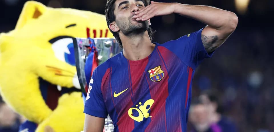 Player celebrating with trophy and mascot backdrop