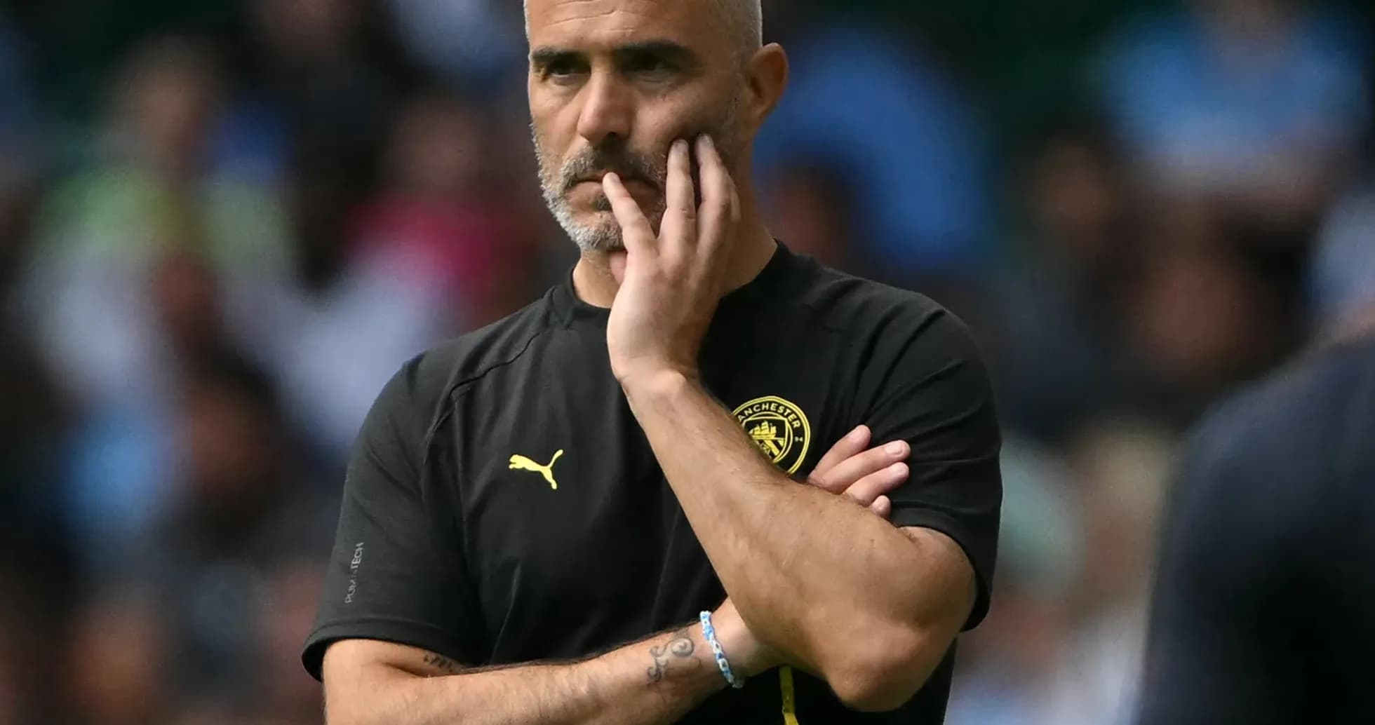 Manager observing the game with thoughtful expression