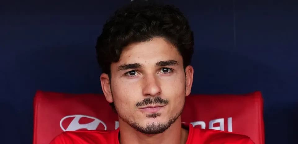 Player sitting on the bench in team jersey