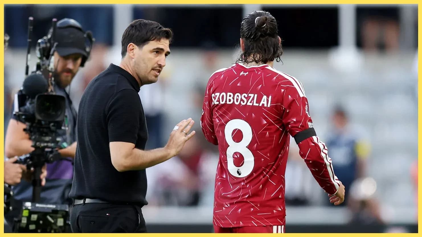Coach discussing strategy with player Szoboszlai on field