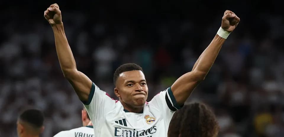 Player celebrating victory with raised arms in stadium
