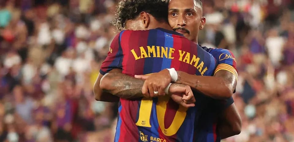 Two FC Barcelona players embracing on the field