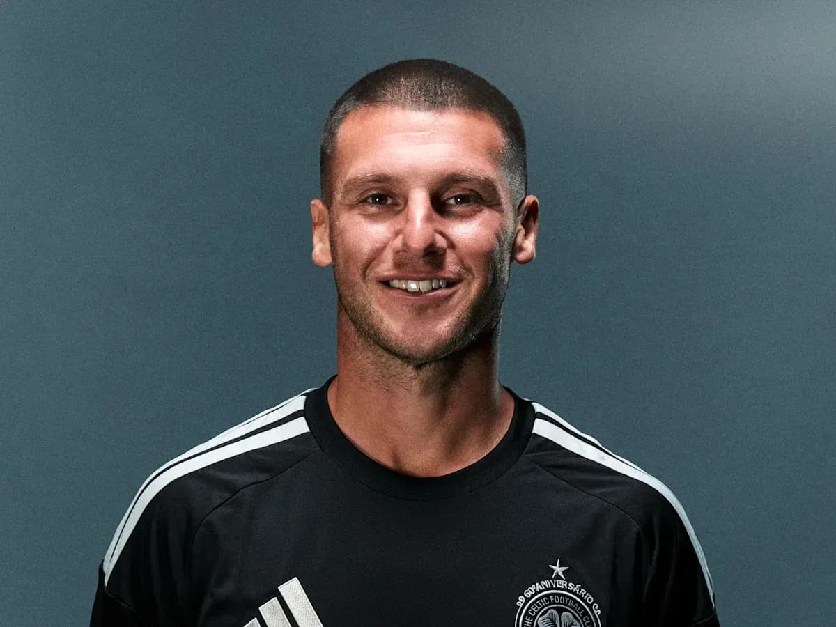 Player posing in black jersey with team logo