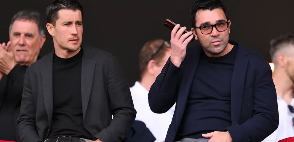 Two men seated in the stands during an event