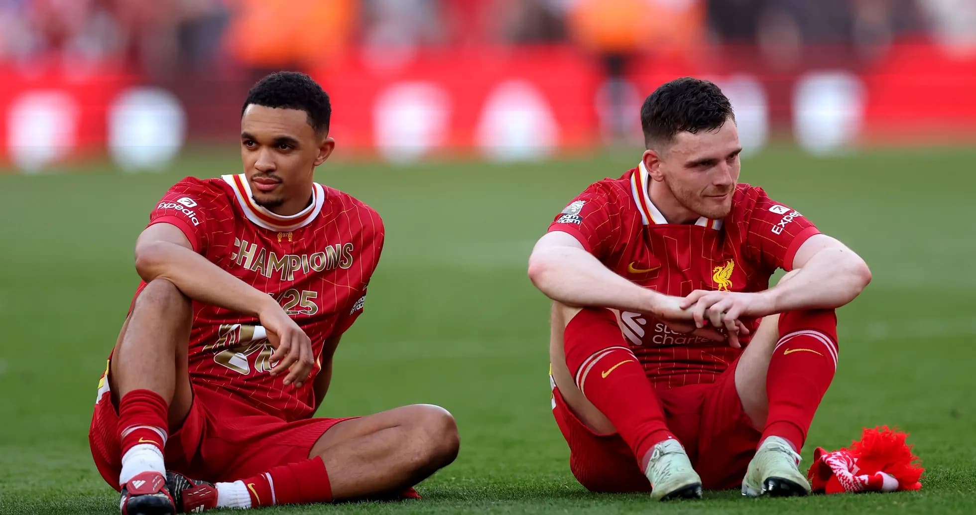 Two Liverpool players sitting on the pitch