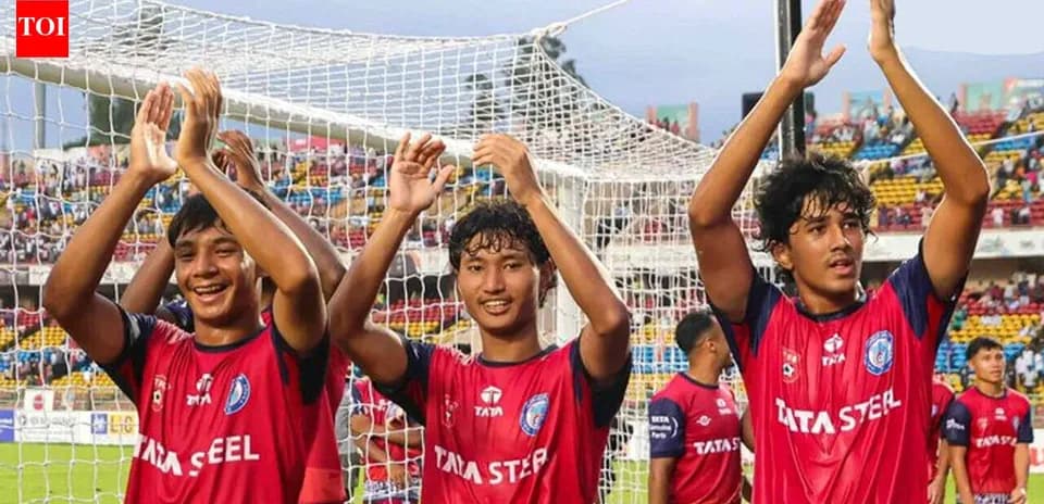 Three players celebrating in front of the goal net